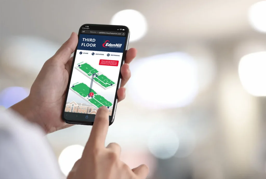 Person's hands holding a smartphone and pointing to use green mobile digital wayfinding dignage diagram of Third Floor medical facility floors for Eden Hill Medical Center.
