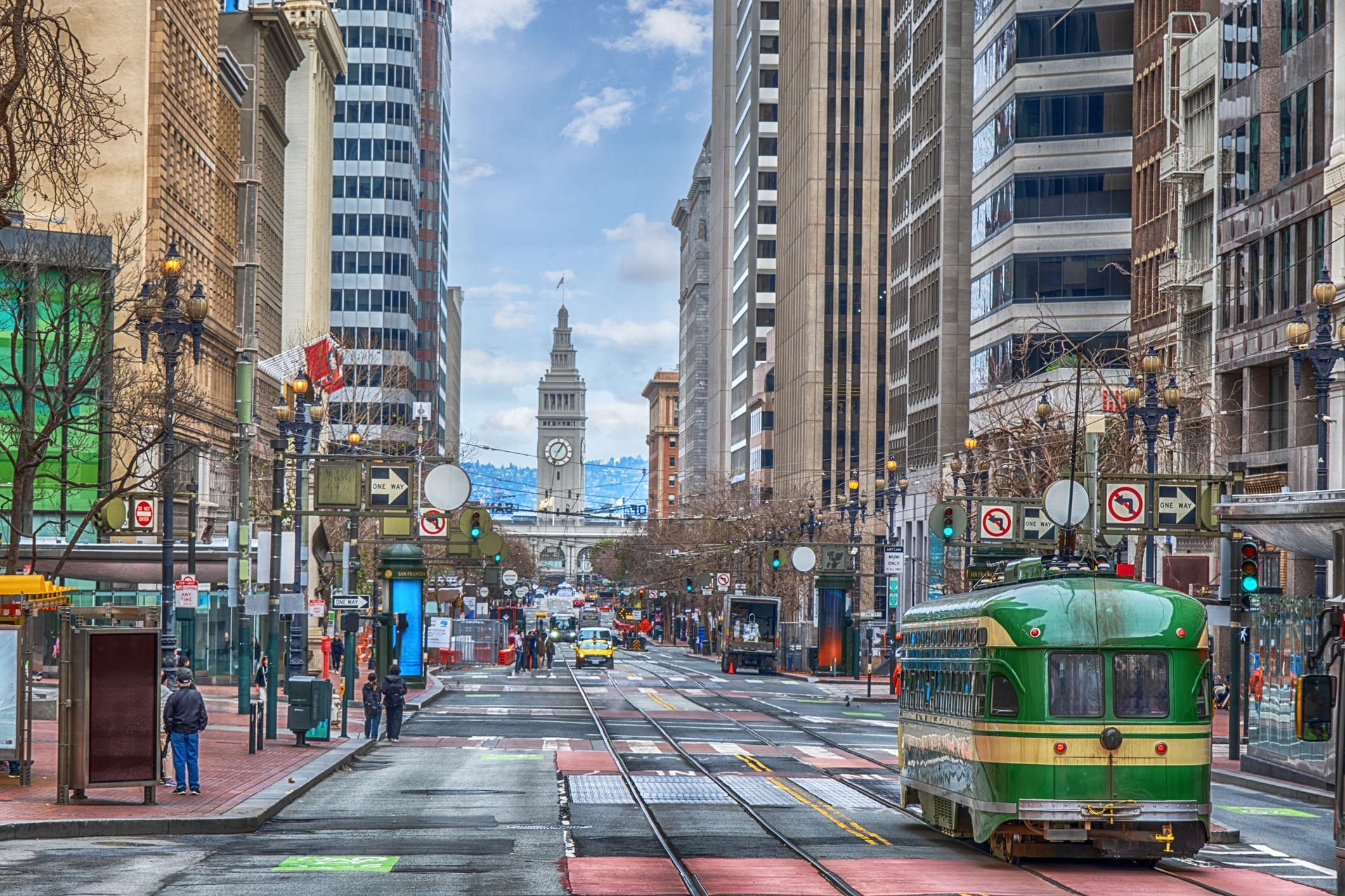 Bustling Market Street in San Francisco in the daytime showing the clock at Ferry Terminal.