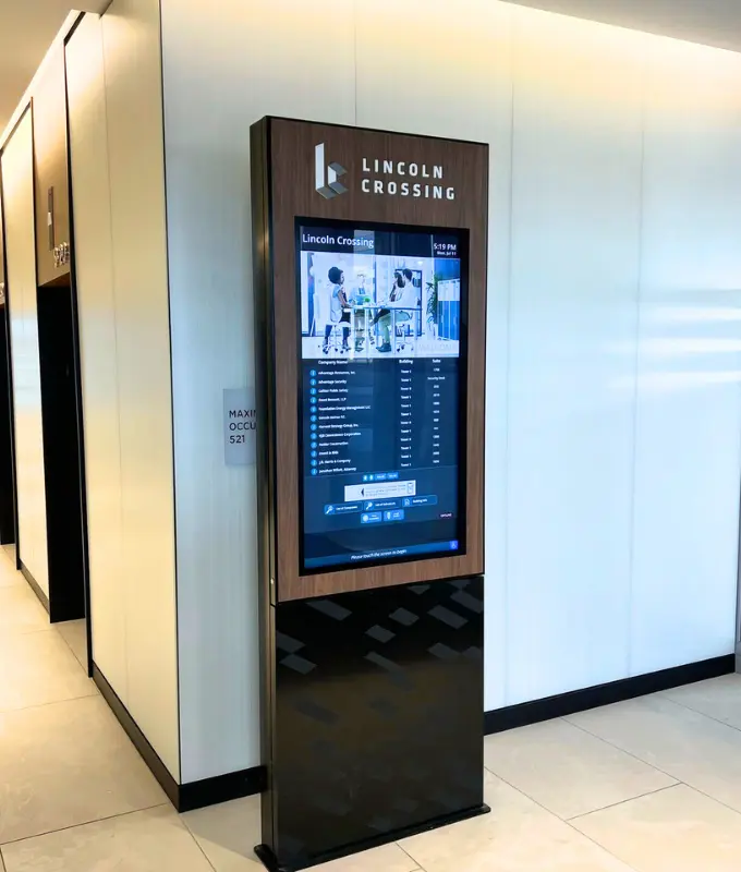 Freestanding digital lobby kiosk in a modern office building providing tenant directories, navigation, and building information to improve the tenant and visitor experience.