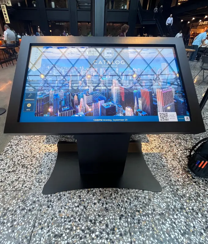 Large touchscreen digital lobby display sharing directories and building information to reduce front desk questions and improve tenant communication in a commercial property.